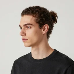 a skinny young white male with a dark curly brown man bun