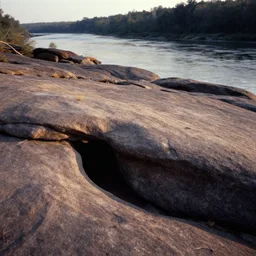 hidden clefts in the rock, bathed in sun, pleasing morning, appealing smooth flat rocky environment sunningrocks by the river's shore, sparse clearing, distant forest, still placid environment matte painting from the fox and the hound ( 1 9 8 1 )
