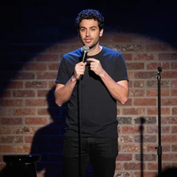 a cinematic scene of mark ellis doing comedy on stage