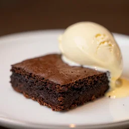 An extreme close-up of a slice brownie with icecream on a plate, food blog, Michelin Star Restaurant, F 2.8, 85mm Velvia 100, high DOF