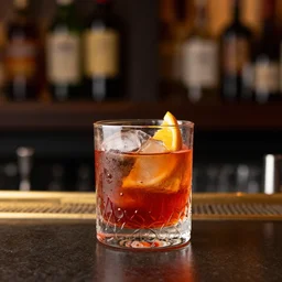 god drinking a negroni at a bar on the lower east side