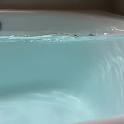 photo of a bathtub with the surface of water visible in it. the whole scene is underwater