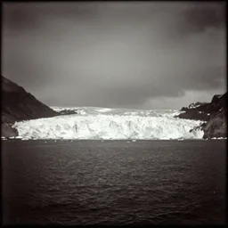 rare photograph of a beautiful ocean, with incredible huge glaciers in the background, beautiful landscape, edwardian photo, historic, shot from afar, very grainy, blurry, damaged, dramatic, night - time, 1 9 0 0, 1 9 1 0 s