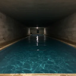 a long, dimly lit tunnel, filled with water like a swimming pool, dark and extremely moody