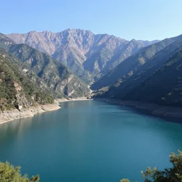 a beautiful image of a breathtaking lake with amazing mountains in the background, there is a kayak in the foreground on the beach