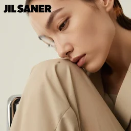 close up of face of female fashion model sitting on chair, beige colors, official jil sander editorial