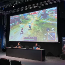 Video game tournament with professional staging and truss lighting, huge projector screens showcasing gameplay Super Smash Brothers Ultimate, moment of victory as the crowd cheers and confetti flies through the air