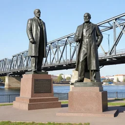 a monument of lenin next to a railway bridge