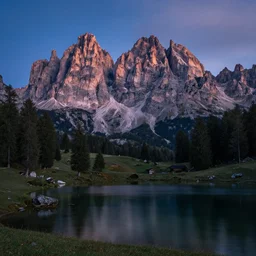 extremely beautiful alpine scenery at night with milkaway, dolomites, calm lake in foreground