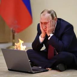 putin with his face in his hands with a laptop which is on fire sitting next to him on the ground.