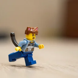 a cat chasing a scared lego man running for his life, low angle, depth of field, 35mm macro