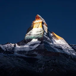 an epic photo at nighttime of the matterhorn in the colors of indian flag, projection, illuminated on the matterhorn mountain at night