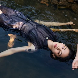 close up of fashion model floating in water of a river, top view, wearing prada dress, harper's bazaar editorial, highly detailed