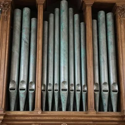 a church organ with pipes shaped like human larynxes made from malachite