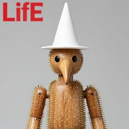 realistic photo of a human model doll made of wood and covered with white dots, covered with brass spikes needles, with a birds beak instead of the nose, hat made of white cone, center straight composition, front view 2 0 0 0, life magazine photo, museum archival photo