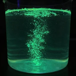 a container with water and luminescent particles inside of it.