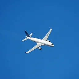 Aerial photograph of an airplane soaring in an azure blue sky.