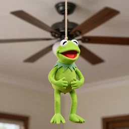 Photograph of Kermit the frog puppet hanging from a rope from a spinning ceiling fan, DSLR, real