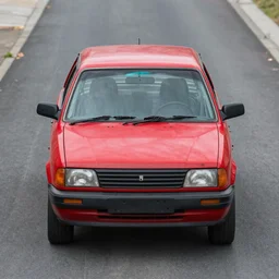 front view red car oxidized with the broken windshield, in the street, a dog walking