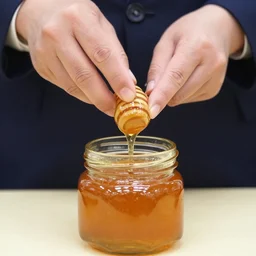 Xi Jinping eating honey out of a jar with his hands.