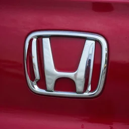 stillframe of a 2 0 0 0 honda logo in dark red comor in the initial d series