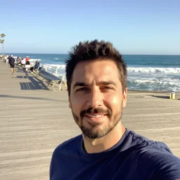 iphone selfie of a man on the boardwalk with the ocean in the background