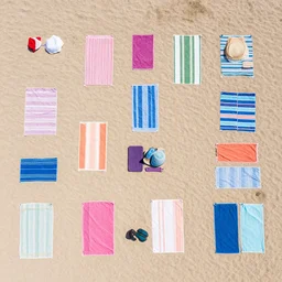 Aerial view of a beach with tons of towels of differents colors on the beach, award photography