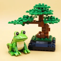 a LEGO frog next to a bonsai tree