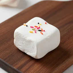 photograph of a delicious marshmallow cube with sprinkles on a dark wooden chopping board, pastel colours, hessian cloth, styled food photography, photorealistic, 4 k