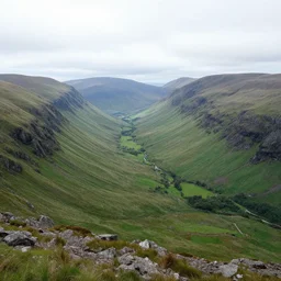 view from the top of a scottish mountain towards a lush valley