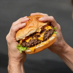 strong veiny arm gripping cheeseburger so hard it's smashed