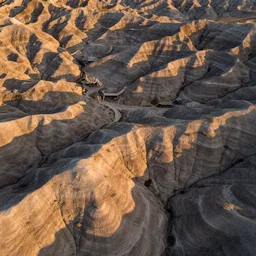 aerial overhead very close up shot of badlands ground in golden hour lighting