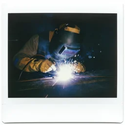 a polaroid of a person welding, cinematic atmosphere