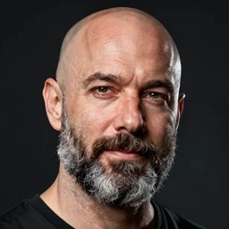 portrait of DC comics comic book artist Ethan Van Sciver, chunky with a bald head and a trimmed grey beard