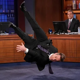 andy richter wearing a black suit and necktie doing the backslide on the set of law and order