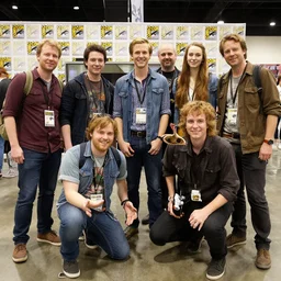 a group of multiple ethan van scivers posing for a picture at a comic con convention