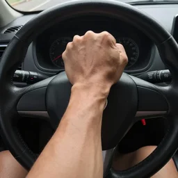 muscular arm gripping a steering wheel at the top, first person pov, detailed,