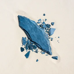 aerial photography high contrast angular sharp cool blue slate shards scattered in the pale sand