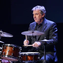 Former Prime Minister of Sweden, Göran Persson, playing a drum solo for Miles Davis on stage. Cinematic lighting, 8k