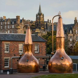 a beautiful painting of Holyrood Distillery and Arthur's Seat in Edinburgh, brick building, golden hour, copper stills, whisky, trending on artstation