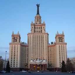 a wide shot of a soviet beautiful brutalist monumental multi - building structure, tall buildings with spaceship parking lots on top, with many rounded elements sprouting from the base tower creating a feel of an organic structure, photography shot at blue hour