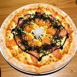 a pizza with soy sauce, raw salmon, and seaweed