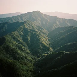 symmetry!! a 2 8 mm macro tilt shift aerial view of a beautiful lush mountain range, photography, film, film grain, canon 5 0 mm, cinematic lighting, golden hour, hazy,
