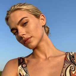 stylistic photograph of an olive skinned blonde female model in her twenties, her hair pinned up, wearing a designer top, looking content, focused on her neck, photo realistic, extreme detail skin, natural beauty, no filter, slr, golden hour, 4 k, high definition, selfie