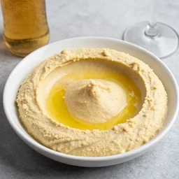 a hummus plate with a beer bottle, food photography