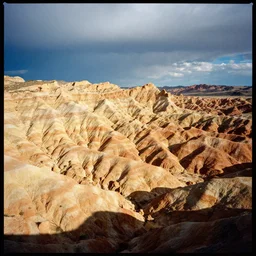 photo of shiprock, hogback ridge, high aerial view, the foreground is brightly lit by sun, and the background clouds are dark and foreboding. kodak portra 4 0 0