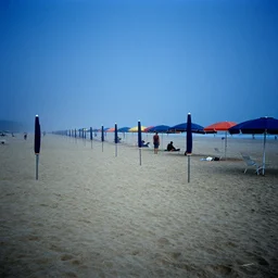 people, rows of open beach umbrellas lining a sandy beach, fog, deep blue mood, colorful, contemporary archival color photograph print from the original negative, by stanley kubrick