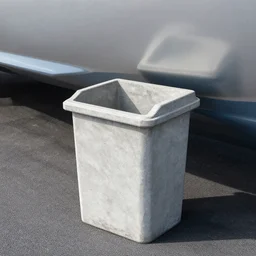 dry dock concrete clamshell grill garbage can on an abandoned shiny angular motorboat hull on the asphalt,