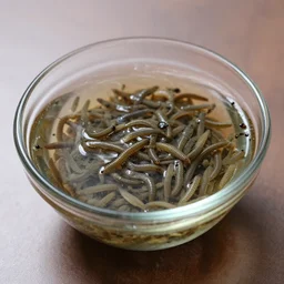 glass bowl full of grub worms on a table