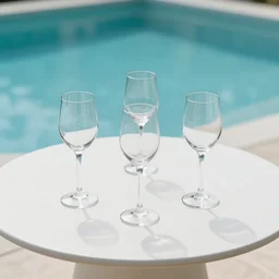 5 5 mm photo of wineglass drink on a zen minimalist round white table with gorgeous pool in the background. highly detailed 8 k. intricate. lifelike. soft light,